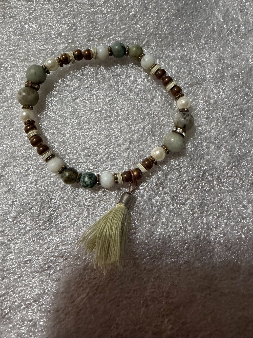 Green and White Beaded Stretch Bracelet with Tassel and Gold Accents